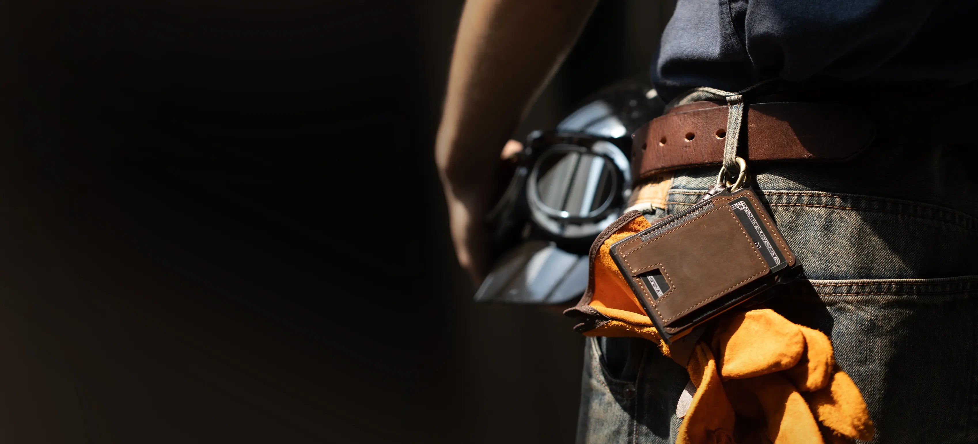 Vertical lifestyle banner showing a brown 1979 wallet attached at the waist by its hanging loop while worn with jeans and everyday gear.