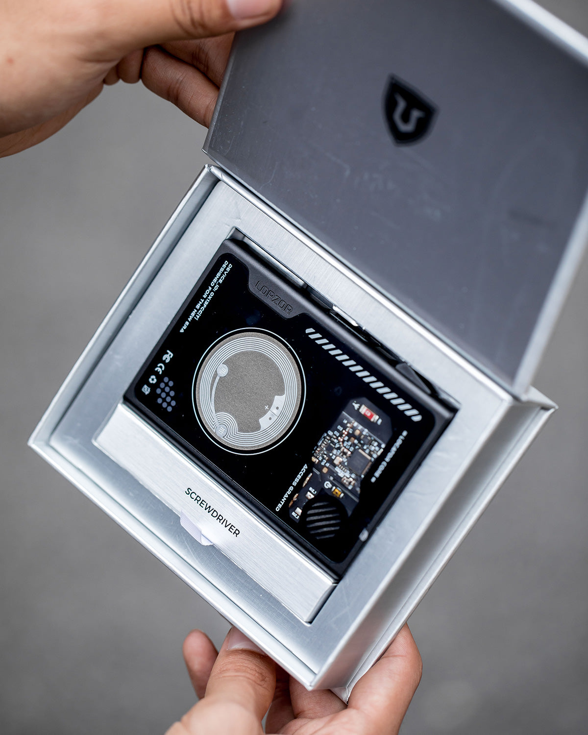 Opened presentation box revealing a black wallet placed in a fitted tray with accessories arranged below.