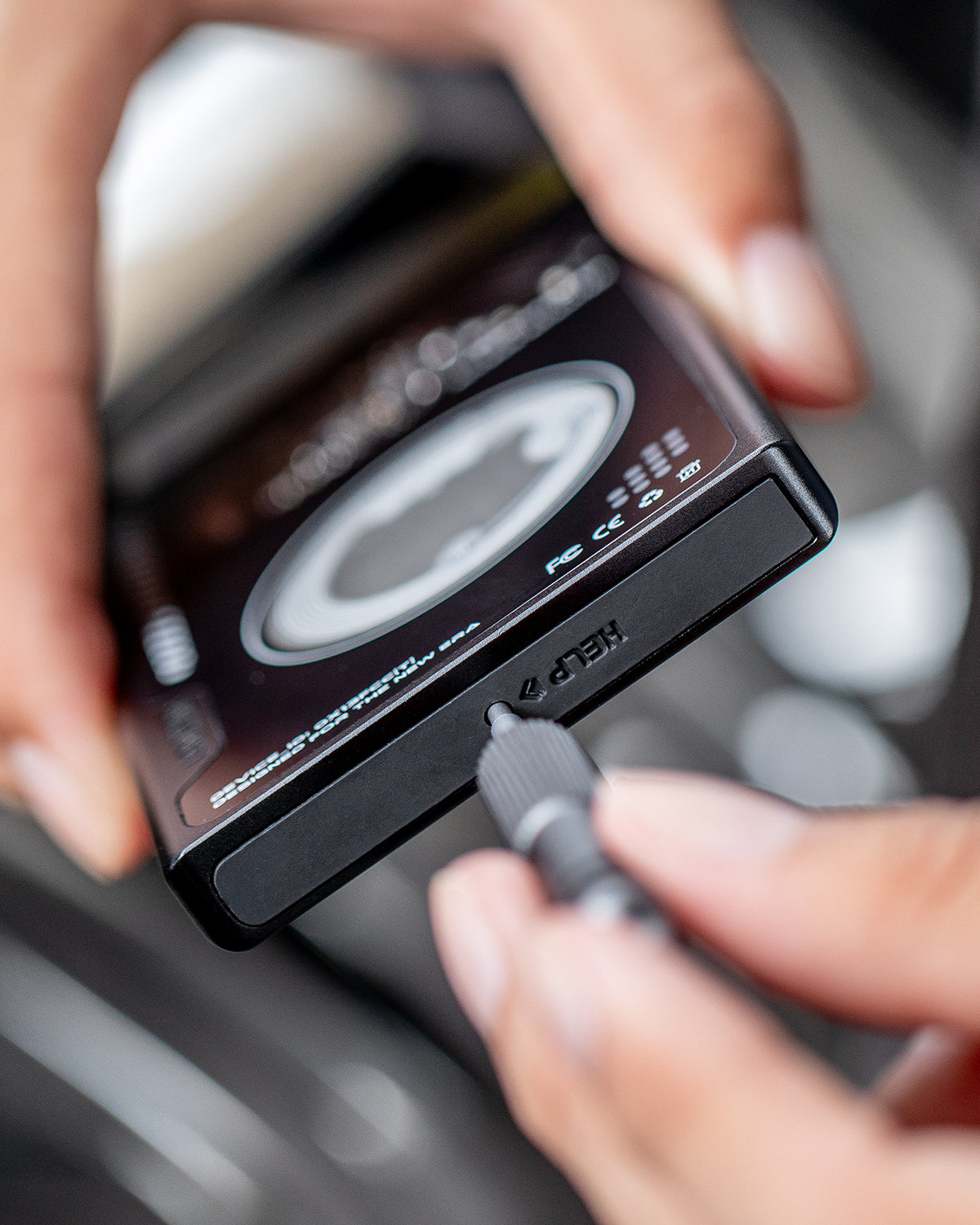 Close-up of a small screwdriver adjusting the side screw on the black wallet body.